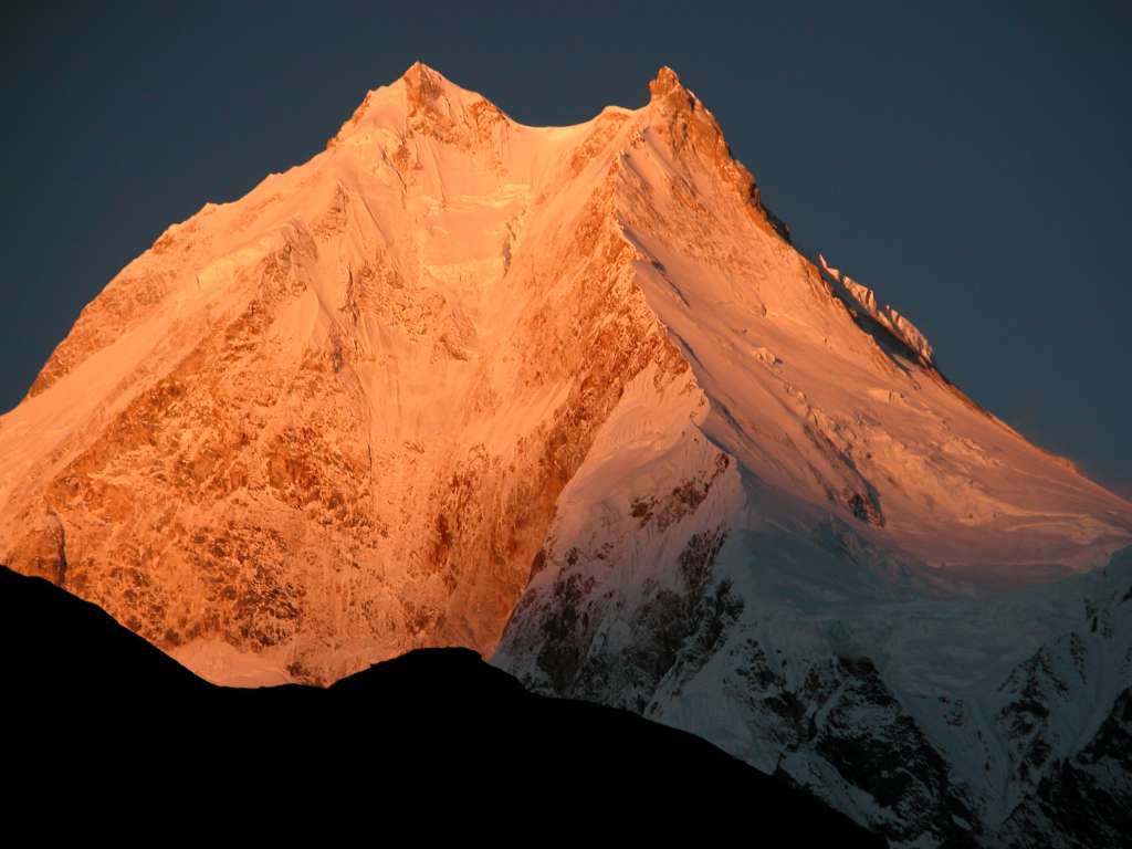 Manaslu 07 01 Manaslu Sunrise From Syala I waited with anticipation for the sun to rise and hit the mountains. Wow! The subtle changes of the light on Manaslu are terrific, turning from grey to pink to orange to yellow and then to white, all within a few minutes.